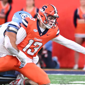 Oct 31, 2025; Syracuse, New York, USA; Syracuse Orange quarterback Joseph Filardi (13) loses a fumble on a tackle by North Carolina Tar Heels defensive lineman Melkart Abou Jaoude (9) in the fourth quarter at the JMA Wireless Dome. Mandatory Credit: Mark Konezny-Imagn Images