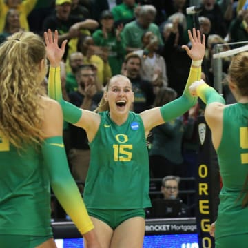 Oregon's Mimi Colyer, center, celebrates the winning shot against Arkansas during the final set in their NCAA Round 2 match in Eugene Dec. 3, 2022.