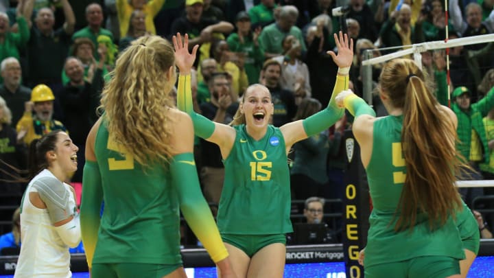 Oregon's Mimi Colyer, center, celebrates the winning shot against Arkansas during the final set in their NCAA Round 2 match in Eugene Dec. 3, 2022.