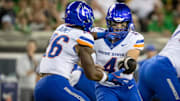 Boise State quarterback Maddux Madsen hands the ball off to running back Sire Gaines.