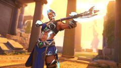Overwatch 2's Junker Queen hoisting a glowing axe-rifle over her shoulders as the sun sets behind her
