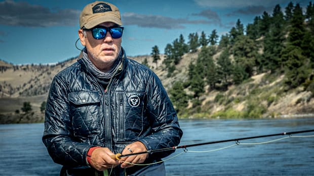 A fly angler wearing a best of technical jacket while he fly fishes.