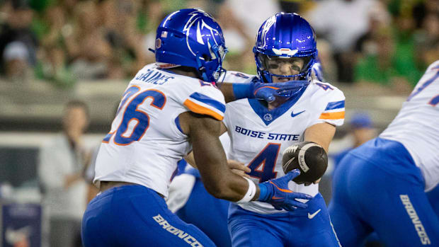 Boise State quarterback Maddux Madsen hands the ball off to Boise State running back Sire Gaines