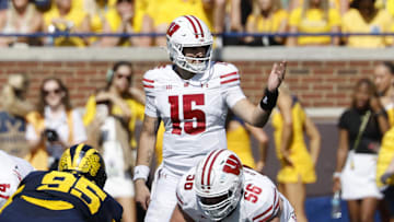 Oct 4, 2025; Ann Arbor, Michigan, USA;  Wisconsin Badgers quarterback Hunter Simmons (15) gets set to run a play in the first half against the Michigan Wolverines at Michigan Stadium.