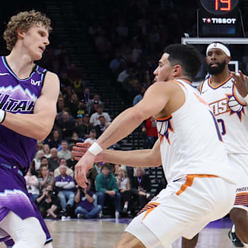 Oct 27, 2025; Salt Lake City, Utah, USA; Utah Jazz forward Lauri Markkanen (23) moves the ball against Phoenix Suns guard Devin Booker (1) during the second half at Delta Center. Mandatory Credit: Rob Gray-Imagn Images
