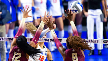 Florida Gators outside hitter Kennedy Martin (18) spikes the ball through the hands of Florida St. outside hitter Kyleene Filimaua (12) and Florida St. middle blocker Khori Louis (8) in the first set at Exactech Arena at The Stephen C O'Connell Center in Gainesville, FL on Tuesday, September 17, 2024 against the Florida State Seminoles. [Doug Engle/Gainesville Sun]