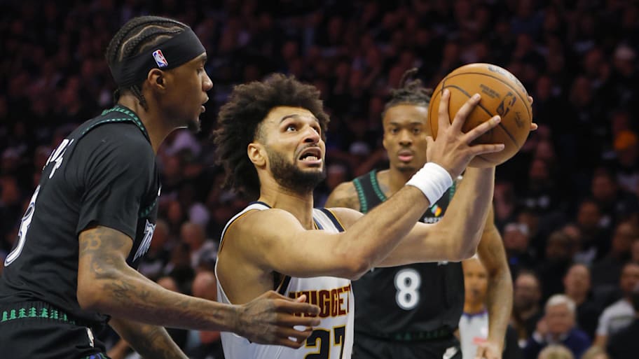 Denver Nuggets guard Jamal Murray goes to the basket past Minnesota Timberwolves forward Jaden McDaniels.
