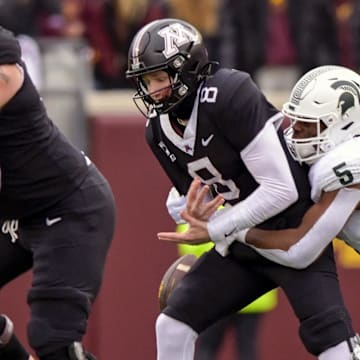 Oct 28, 2023; Minneapolis, Minnesota, USA; Minnesota Golden Gophers quarterback Athan Kaliakmanis (8) is sacked by Michigan State Spartans linebacker Jordan Hall (5) during the first quarter at Huntington Bank Stadium. Mandatory Credit: Nick Wosika-Imagn Images