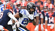 Sep 27, 2025; Syracuse, New York, USA; Duke Blue Devils running back Nate Sheppard (20) tries to run past Syracuse Orange defensive back Braheem Long Jr. (0) in the third quarter at the JMA Wireless Dome. Mandatory Credit: Mark Konezny-Imagn Images
