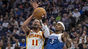 Apr 12, 2024; Minneapolis, Minnesota, USA; Atlanta Hawks guard Trae Young (11) drives to the basket past Minnesota Timberwolves forward Jaden McDaniels (3) in the first half at Target Center. Mandatory Credit: Jesse Johnson-Imagn Images