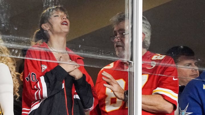 Oct 12, 2023; Kansas City, Missouri, USA; Recording artist Taylor Swift laughs while talking to Ed Kelce (Travis Kelce's father) during the second half of the game between the Kansas City Chiefs and Denver Broncos at GEHA Field at Arrowhead Stadium. 