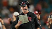 Oct 25, 2025; Miami Gardens, Florida, USA; Stanford Cardinal interim head coach Frank Reich reads a play card against the Miami Hurricanes during the third quarter at Hard Rock Stadium. Mandatory Credit: Sam Navarro-Imagn Images