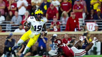 Sep 6, 2025; Norman, Oklahoma, USA;  Michigan Wolverines quarterback Bryce Underwood (19) runs past Oklahoma Sooners linebacker Sammy Omosigho (7) during the second half at Gaylord Family-Oklahoma Memorial Stadium. Mandatory Credit: Kevin Jairaj-Imagn Images