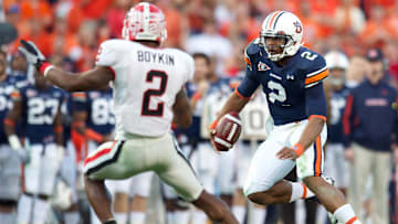 Nov 13, 2010; Auburn, AL, USA; Auburn Tigers quarterback Cam Newton (2) runs for a first down past Georgia Bulldogs cornerback Brandon Boykin (2) in the second quarter at Jordan-Hare Stadium.  Mandatory Credit: Dale Zanine-Imagn Images