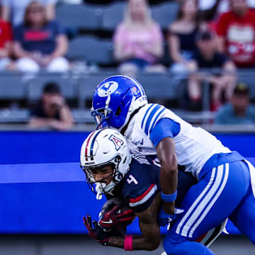 Oct 11, 2025; Tucson, Arizona, USA; Brigham Young Cougars cornerback Evan Johnson (0) tackles Arizona Wildcats wide receiver Kris Hutson (4) during the first quarter of the game at Arizona Stadium. Mandatory Credit: Aryanna Frank-Imagn Images