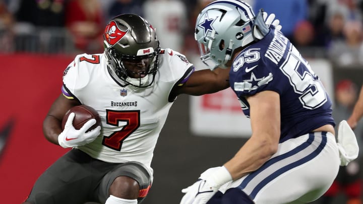 Jan 16, 2023; Tampa, Florida, USA; Tampa Bay Buccaneers running back Leonard Fournette (7) rushes the ball against the Dallas Cowboys linebacker Leighton Vander Esch (55) in the first half during the wild card game at Raymond James Stadium. Mandatory Credit: Kim Klement-USA TODAY Sports