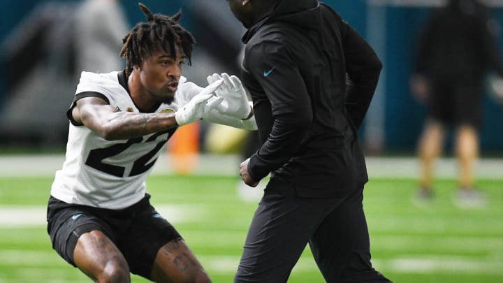 Jacksonville Jaguars cornerback Jarrian Jones (22) runs a drill around defensive assistant/cornerbacks coach Corey Robinson during Friday's rookie minicamp session. 