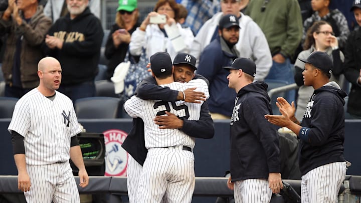 New York Yankees first baseman Mark Teixeira (25) is embraced by starting pitcher CC Sabathia (52) after being removed from his final Major League game against the Baltimore Orioles at Yankee Stadium on Oct. 2, 2016.