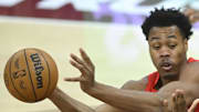 Toronto Raptors forward Scottie Barnes looks to pass beside Cleveland Cavaliers forward Nae'Qwan Tomlin.