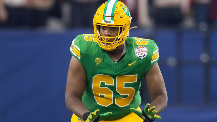 Jan 1, 2024; Glendale, AZ, USA; Oregon Ducks offensive lineman Ajani Cornelius (65) against the Liberty Flames during the 2024 Fiesta Bowl at State Farm Stadium. Mandatory Credit: Mark J. Rebilas-USA TODAY Sports