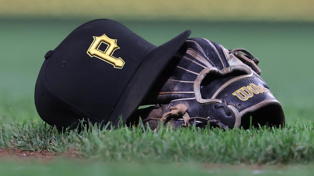 Sep 16, 2025; Pittsburgh, Pennsylvania, USA; A hat and glove belonging to Pittsburgh Pirates third baseman Jared Triolo (not pictured) on the field against the Chicago Cubs during the sixth inning at PNC Park. Mandatory Credit: Charles LeClaire-Imagn Images