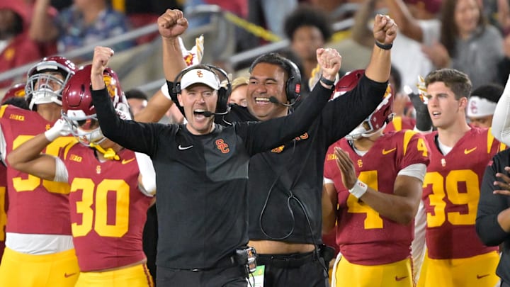 Oct 11, 2025; Los Angeles, California, USA;  USC Trojans head coach Lincoln Riley (wearing white visor) celebrates along with defensive end coach Shaun Nua after kicker Ryon Sayeri (48) hit a 54-yard field goal in the second half against the Michigan Wolverines at United Airlines Field at the Los Angeles Memorial Coliseum. Mandatory Credit: Jayne Kamin-Oncea-Imagn Images