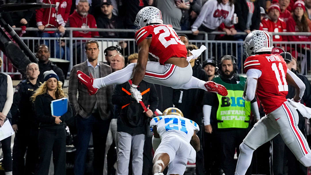 Ohio State Buckeyes running back James Peoples (20) hurdles over UCLA Bruins defensive back Cole Martin (21) in the first half of the NCAA college football game at Ohio Stadium on Saturday, Nov. 15, 2025 in Columbus, Ohio.