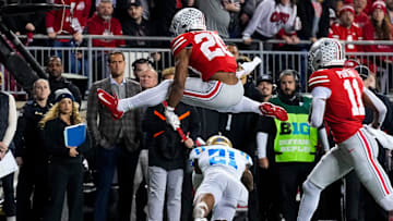 Ohio State Buckeyes running back James Peoples (20) hurdles over UCLA Bruins defensive back Cole Martin (21) in the first half of the NCAA college football game at Ohio Stadium on Saturday, Nov. 15, 2025 in Columbus, Ohio.