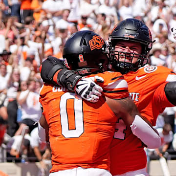 Oklahoma State's Ollie Gordon II (0) celebrates a touchdown with Preston Wilson (74) in double over time of the college football game between the Oklahoma State Cowboys and the Arkansas Razorbacks at Boone Pickens Stadium in Stillwater, Okla.,, Saturday, Sept., 7, 2024.