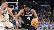Mar 24, 2024; Indianapolis, IN, USA; Utah State Aggies guard Ian Martinez (4) dribbles against Purdue Boilermakers forward Mason Gillis (0) during the first half at Gainbridge FieldHouse. Mandatory Credit: Trevor Ruszkowski-Imagn Images