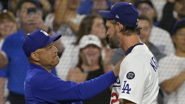 Dodgers starting pitcher Clayton Kershaw (22) is congratulated by manager Dave Roberts after his 3000th career strikeout.