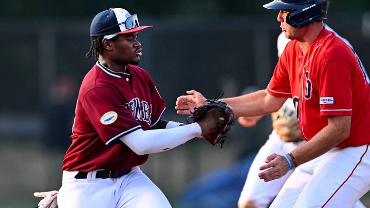 FALMOUTH. 07/27/24 West third baseman Murf Gray catches Ethan Petry of the East between bases . All Star Cape League game