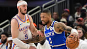 Mar 16, 2025; Milwaukee, Wisconsin, USA; Milwaukee Bucks guard Damian Lillard (0) drives past Oklahoma City Thunder guard Alex Caruso (9) in the second quarter at Fiserv Forum. Mandatory Credit: Benny Sieu-Imagn Images