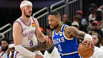Mar 16, 2025; Milwaukee, Wisconsin, USA; Milwaukee Bucks guard Damian Lillard (0) drives past Oklahoma City Thunder guard Alex Caruso (9) in the second quarter at Fiserv Forum. Mandatory Credit: Benny Sieu-Imagn Images