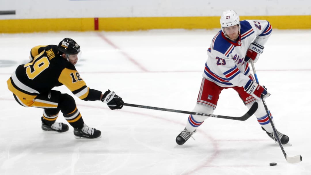 Mar 16, 2024; Pittsburgh, Pennsylvania, USA;  New York Rangers defenseman Adam Fox (23) moves the puck against Pittsburgh Penguins right wing Reilly Smith (19) during the third period at PPG Paints Arena. New York won 7-4. Mandatory Credit: Charles LeClaire-USA TODAY Sports