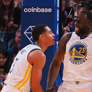 Apr 18, 2022; San Francisco, California, USA; Golden State Warriors forward Draymond Green (23) celebrates with guard Jordan Poole (3) and guard Klay Thompson (11) after a foul against the Denver Nuggets during the second quarter of game two of the first round for the 2022 NBA playoffs at Chase Center. 