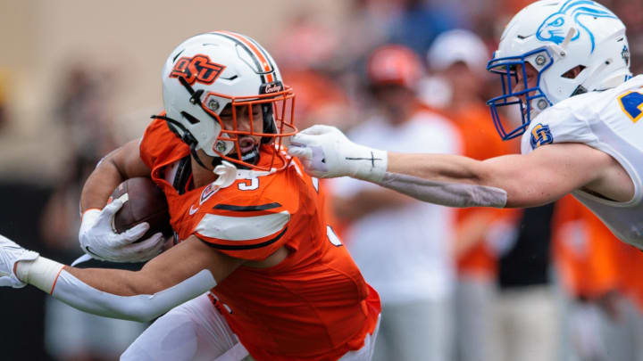 South Dakota State Jackrabbits linebacker Graham Spalding (29) grabs the facemark of Oklahoma State Cowboys running back Sesi Vailahi (3) during the second quarter  at Boone Pickens Stadium.