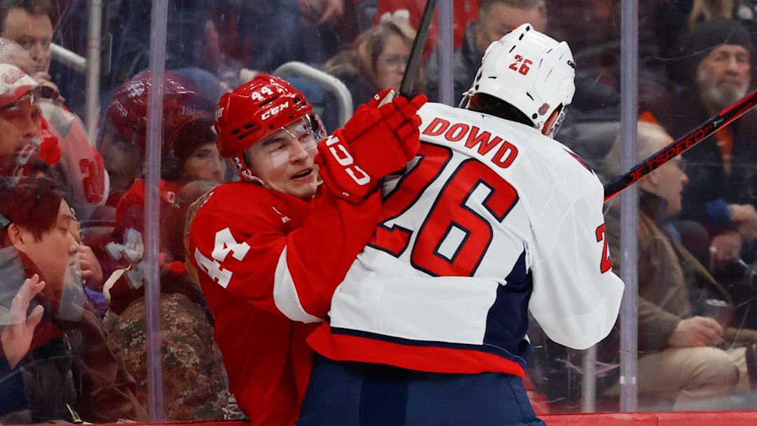 Jan 29, 2026; Detroit, Michigan, USA;  Washington Capitals center Nic Dowd (26) checks Detroit Red Wings defenseman Axel Sandin-Pellikka (44) in the first period at Little Caesars Arena. Mandatory Credit: Rick Osentoski-Imagn Images