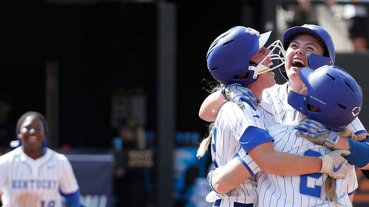Kentucky's Ally Hutchins (7), facing camera, celebrates with Erin Coffel (21) and Grace Lorsung (33) after driving in the game-winning run in the seventh inning of a softball game against Michigan in the first round of the Stillwater Regional of the NCAA Tournament in Stillwater, Okla., Friday, May 17, 2024.