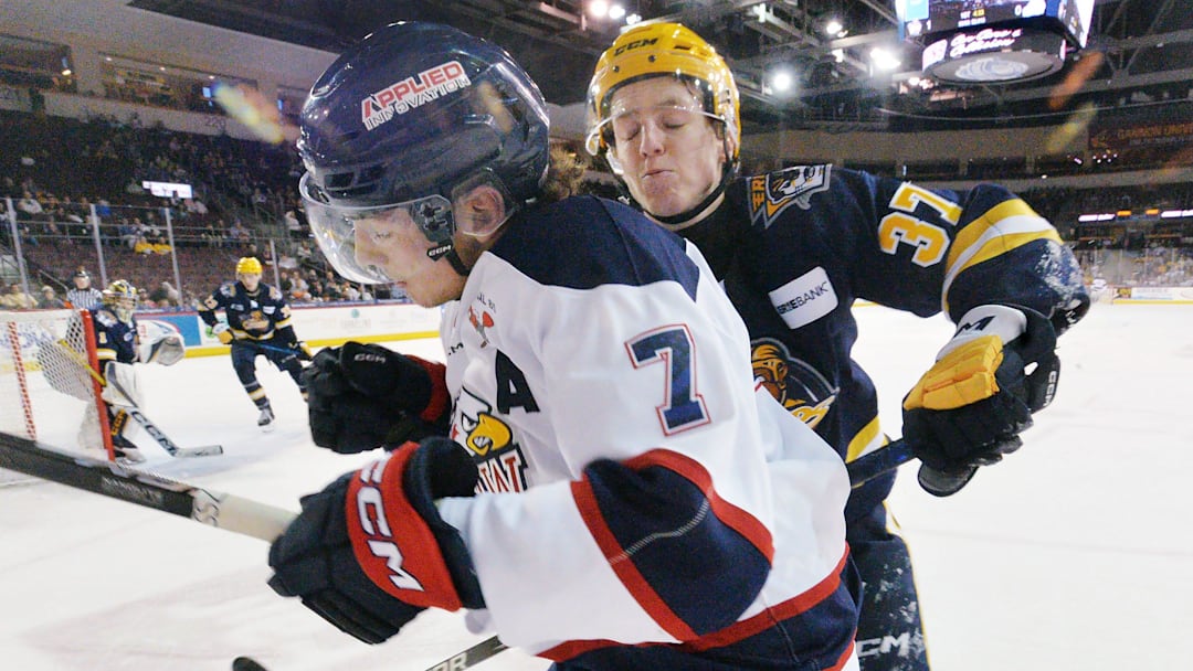 Erie Otters defenseman Quinn McCall, right, checks Saginaw Spirit forward Calem Mangone during an Ontario Hockey League playoff game at Erie Insurance Arena in Erie on April 1, 2025.