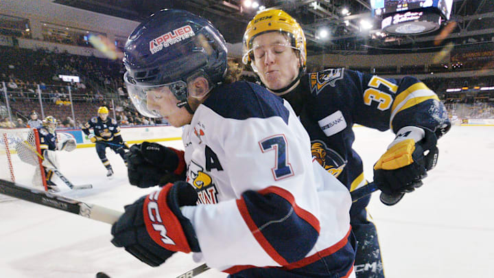 Erie Otters defenseman Quinn McCall, right, checks Saginaw Spirit forward Calem Mangone during an Ontario Hockey League playoff game at Erie Insurance Arena in Erie on April 1, 2025.