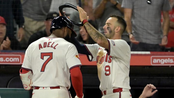 Jul 30, 2024; Anaheim, California, USA; Los Angeles Angels shortstop Zach Neto (9) places a halo on right fielder Jo Adell (7) after hitting a solo home run in the seventh inning against the Colorado Rockies at Angel Stadium. Mandatory Credit: Jayne Kamin-Oncea-USA TODAY Sports