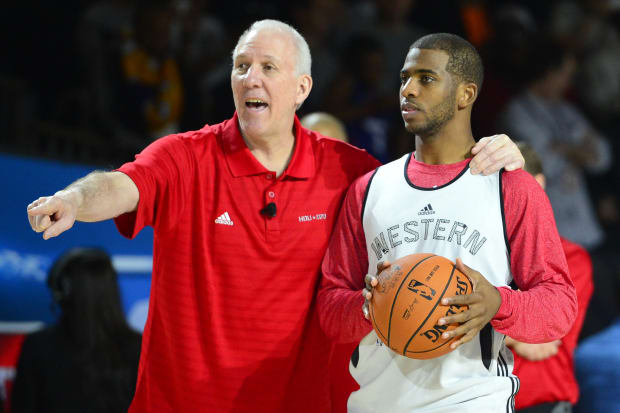 Western Conference coach Gregg Popovich of the San Antonio Spurs talks with guard Chris Paul of the Los Angeles Clippers.