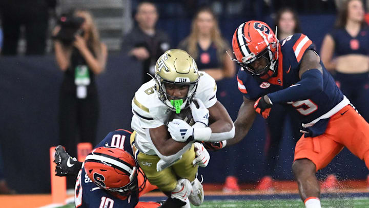 Sep 7, 2024; Syracuse, New York, USA; Georgia Tech Yellow Jackets running back Anthony Carrie (6) is tackled by Syracuse Orange defensive lineman Fadil Diggs (10) and defensive back Alijah Clark (5) in the fourth quarter at the JMA Wireless Dome. Mandatory Credit: Mark Konezny-Imagn Images