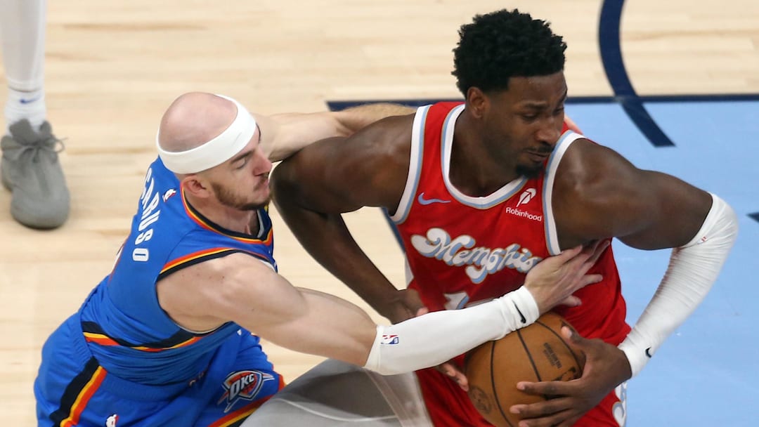 Apr 26, 2025; Memphis, Tennessee, USA; Memphis Grizzlies forward Jaren Jackson Jr. (13) spins to the basket as Oklahoma City Thunder guard Alex Caruso (9) defends during the first quarter during game four for the first round of the 2024 NBA Playoffs at FedExForum.