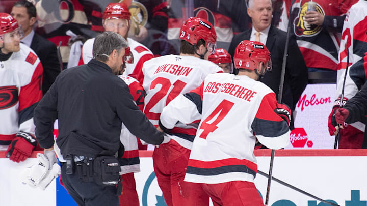Apr 25, 2026; Ottawa, Ontario, CAN; Carolina Hurricanes defenseman Alexander Nikishin (21) is escorted off the ice after being checked in the second period against the Ottawa Senators in game four of the first round of the 2026 Stanley Cup Playoffs at the Canadian Tire Centre. Mandatory Credit: Marc DesRosiers-Imagn