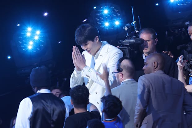 Yang Hansen puts his hands together in celebration after being drafted.