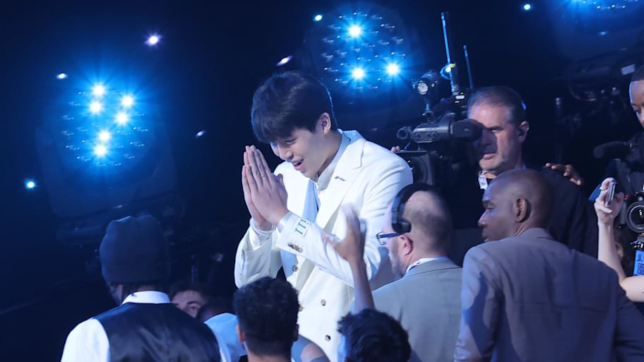 Yang Hansen puts his hands together in celebration after being drafted.
