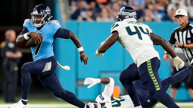 Tennessee Titans quarterback Malik Willis (7) slips past Seattle Seahawks linebacker Jamie Sheriff (44) 