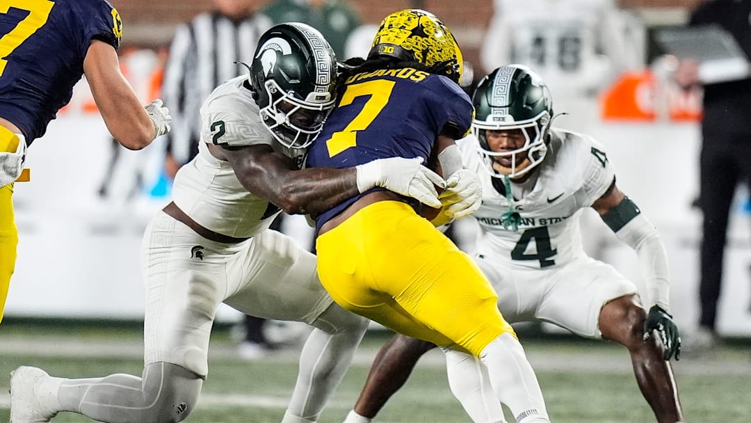 Michigan running back Donovan Edwards (7) is stopped by Michigan State defensive lineman Khris Bogle (2) and defensive back Ed Woods (4) during the first half at Michigan Stadium in Ann Arbor on Saturday, Oct. 26, 2024. Michigan running back Donovan Edwards (7) is stopped by Michigan State defensive lineman Khris Bogle (2) and defensive back Ed Woods (4) during the first half at Michigan Stadium in Ann Arbor on Saturday, Oct. 26, 2024.